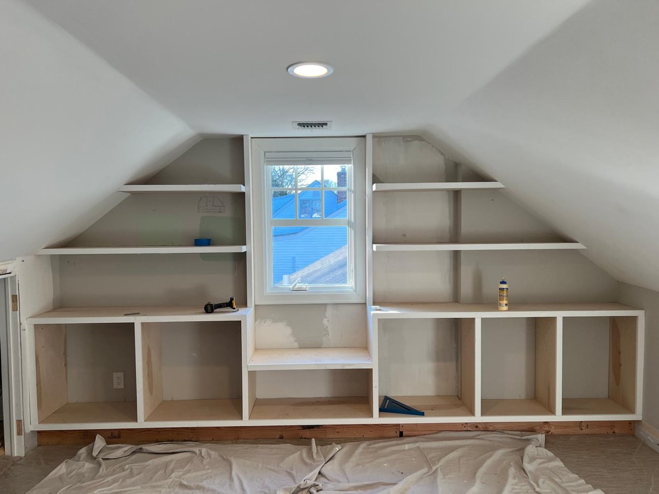 Built-in cabinets and floating shelves fitted to the sloped attic walls