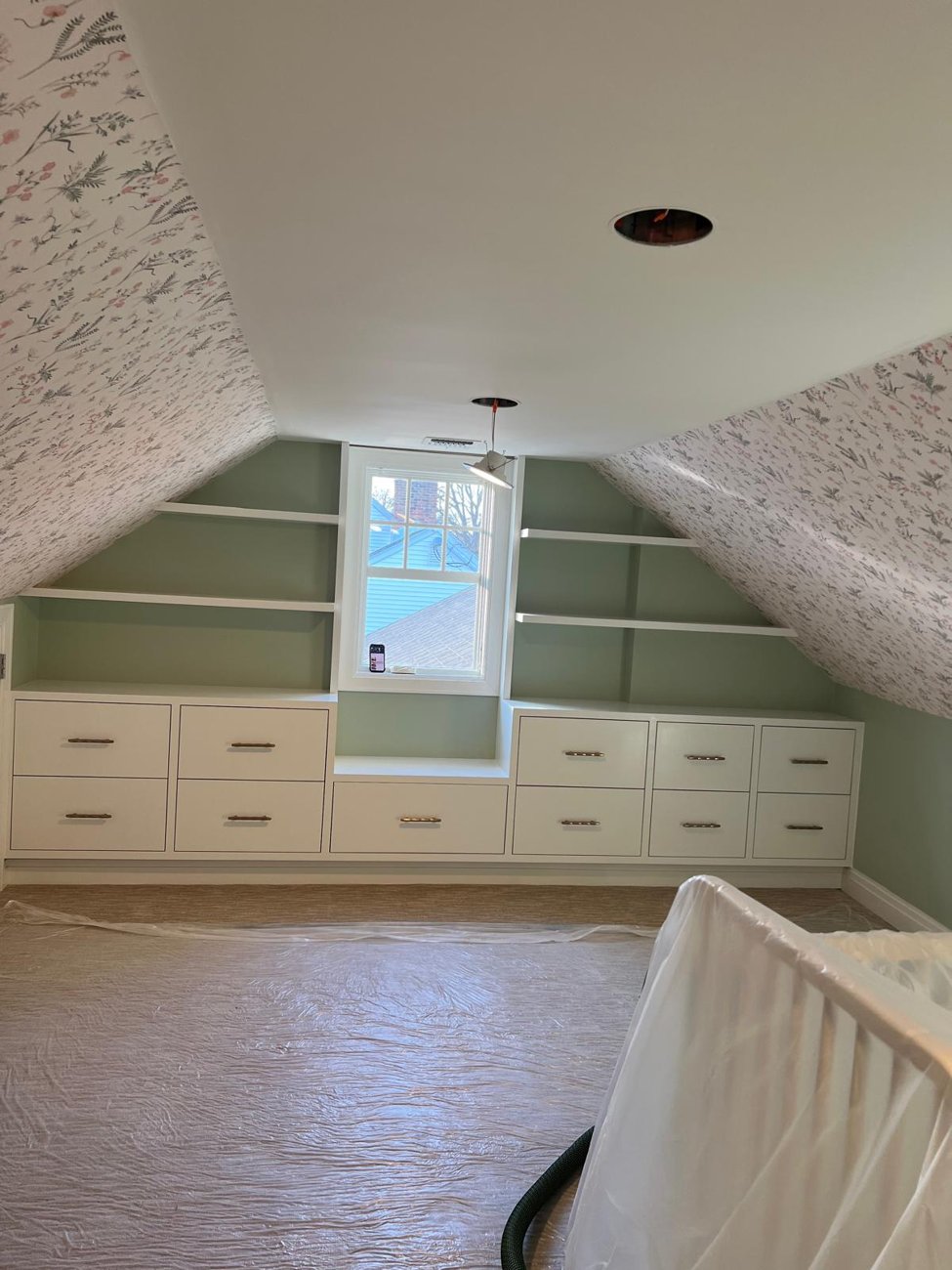 Finished built-ins wrapping the attic corner, painted with wallpapered ceiling