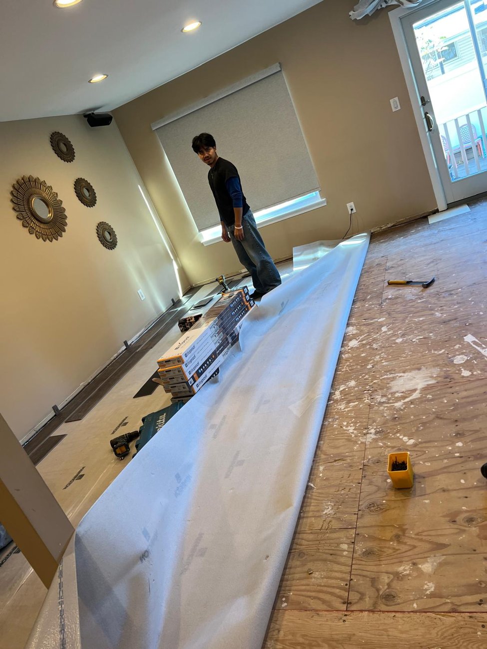 Family room before: bare subfloor and underlayment