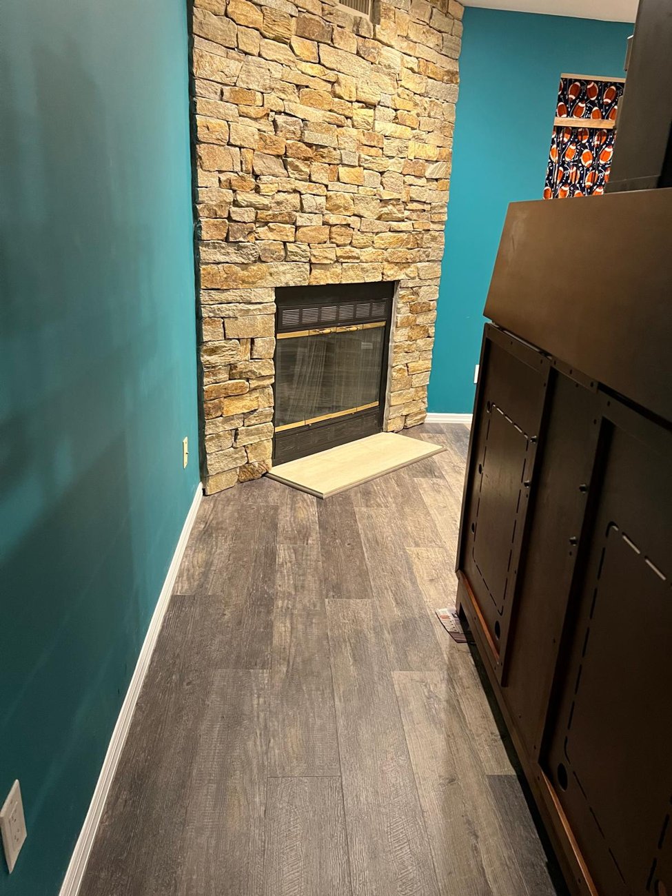 New flooring meeting a stone fireplace, clean edge work