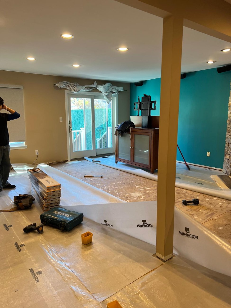 Mid-install: underlayment down, planks going in row by row