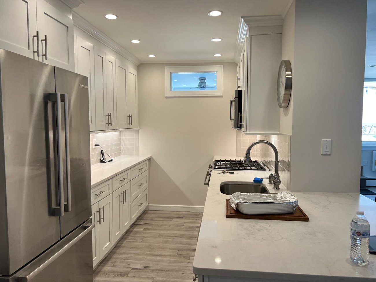 Renovated kitchen with white shaker cabinets and quartz counters