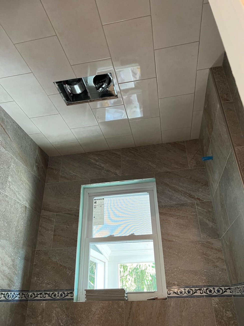Tiled bathroom ceiling and stone walls with window